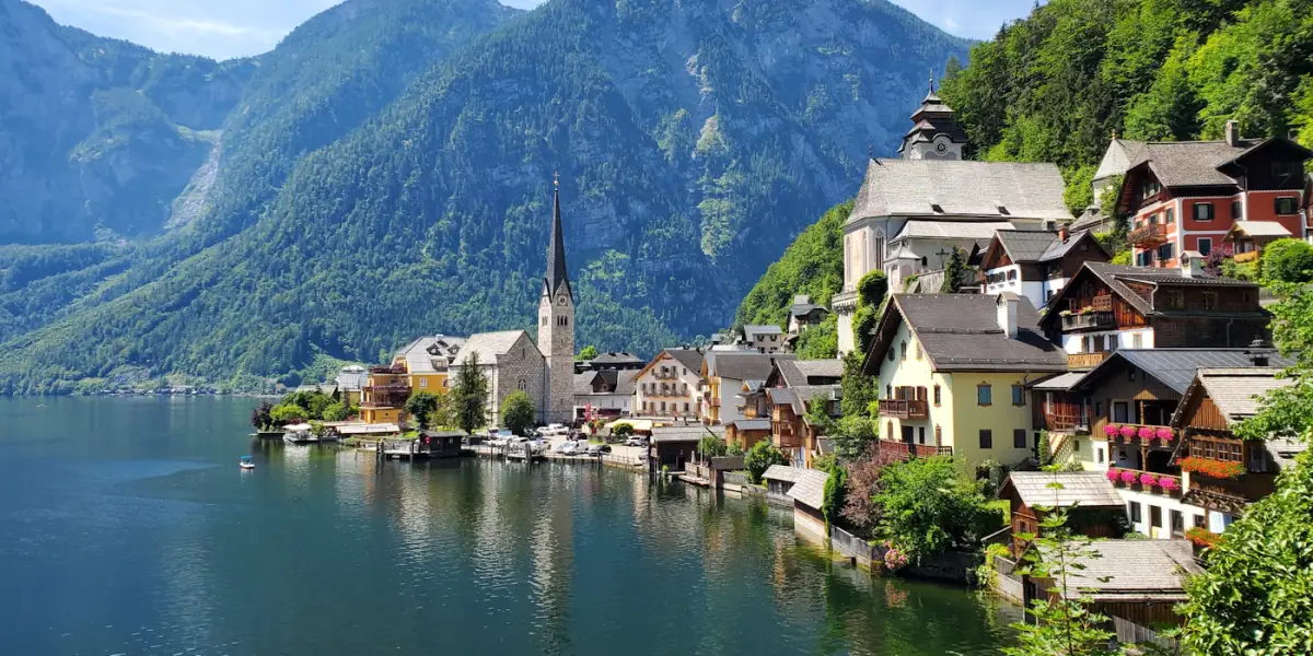 Hallstatt's lakeside houses and church spire on Lake Hallstatt, below steep forested mountains