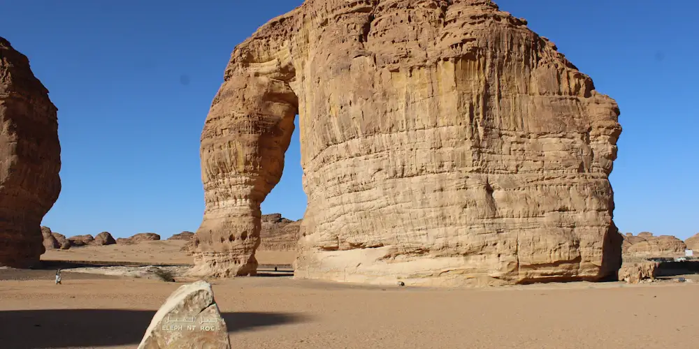 Elephant Rock in AlUla, a huge sandstone outcrop with a trunk-like arch, under a deep blue sky